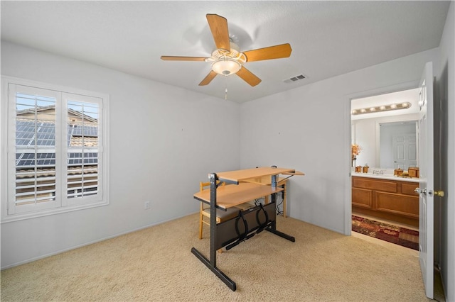 home office with light colored carpet, visible vents, and ceiling fan