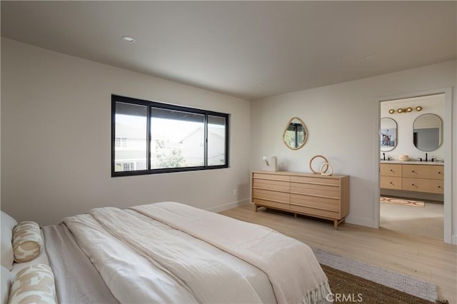 bedroom featuring light wood finished floors, baseboards, connected bathroom, and recessed lighting