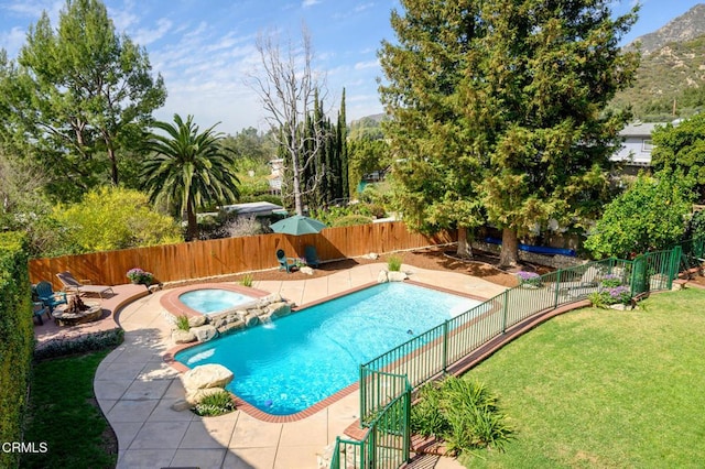 view of pool featuring a fenced backyard, an in ground hot tub, a lawn, a fenced in pool, and a patio area