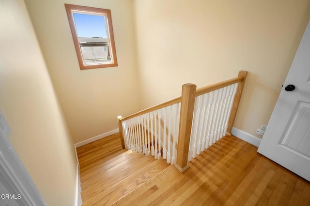 stairs with wood finished floors and baseboards