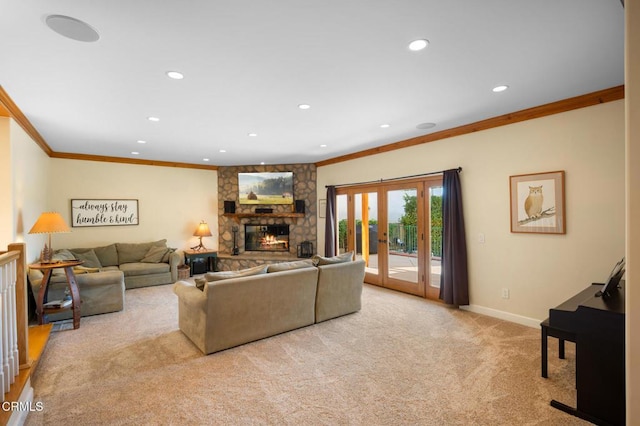 living area with carpet floors, french doors, ornamental molding, a stone fireplace, and baseboards