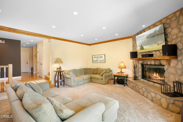 carpeted living area with baseboards, stairs, crown molding, a stone fireplace, and recessed lighting