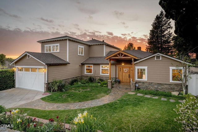 view of front of property featuring driveway, an attached garage, and a lawn