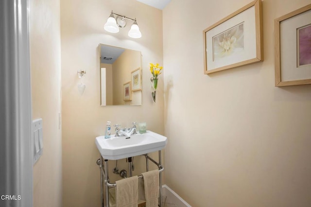 bathroom featuring a sink, visible vents, and baseboards