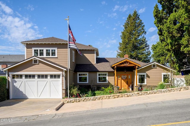 view of front of house featuring driveway, roof with shingles, and an attached garage