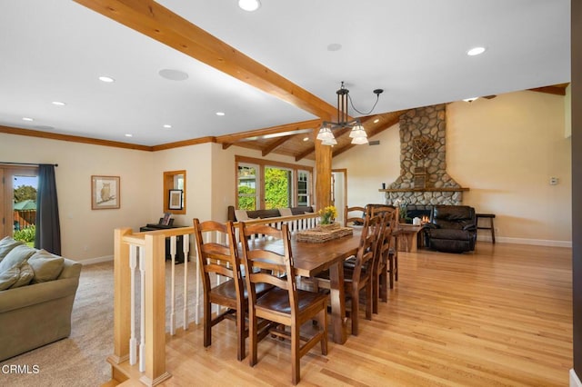 dining room with light wood-type flooring, a fireplace, lofted ceiling with beams, and baseboards