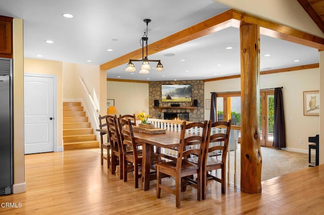 dining room featuring baseboards, ornamental molding, stairs, and light wood-style floors