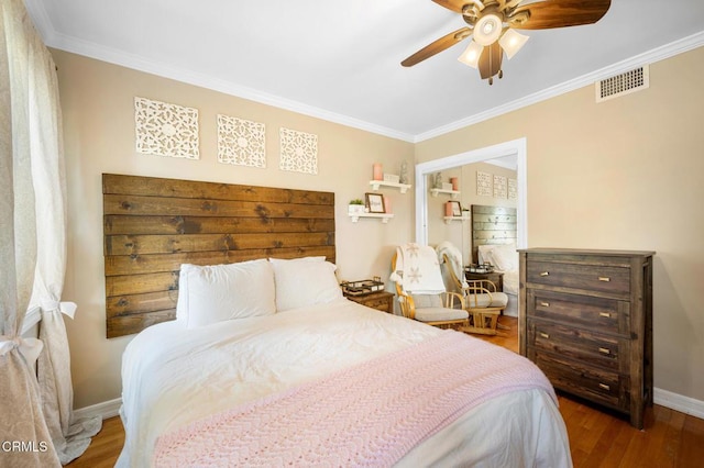 bedroom featuring crown molding, visible vents, and wood finished floors