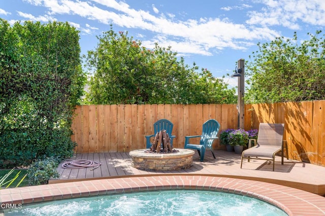 view of pool with a fire pit and fence