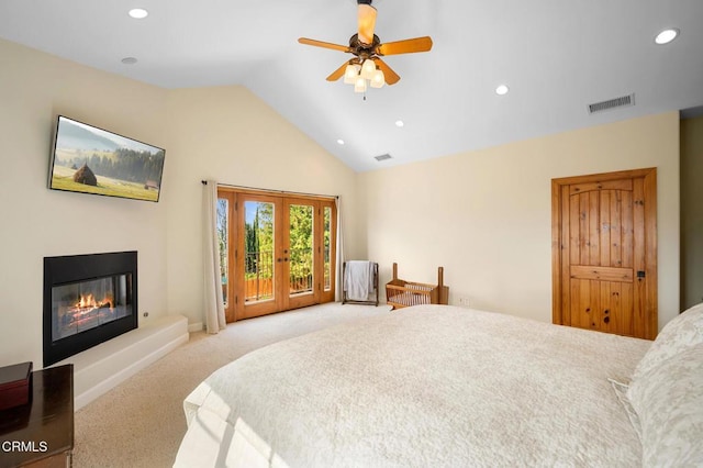 bedroom featuring carpet flooring, visible vents, vaulted ceiling, access to outside, and a glass covered fireplace