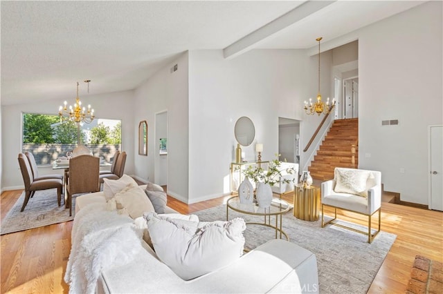 living room with stairs, vaulted ceiling with beams, visible vents, and a chandelier