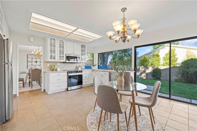 dining room with light tile patterned floors and a chandelier