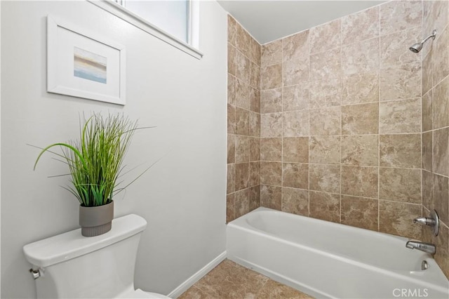 bathroom with tile patterned flooring, shower / washtub combination, toilet, and baseboards