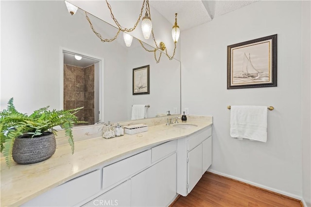 full bath featuring vanity, baseboards, and wood finished floors