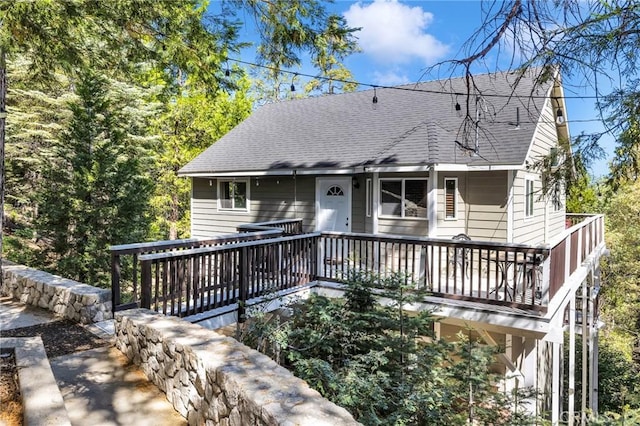 view of front of property with a shingled roof and a wooden deck