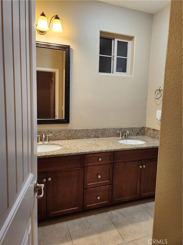 bathroom featuring tile patterned flooring, a sink, and double vanity