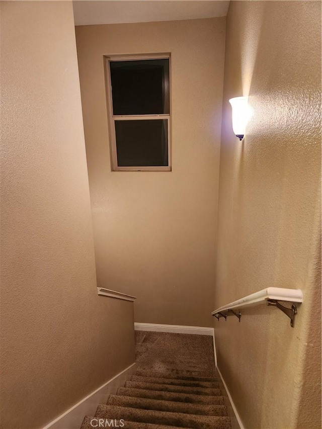 stairway featuring carpet and baseboards