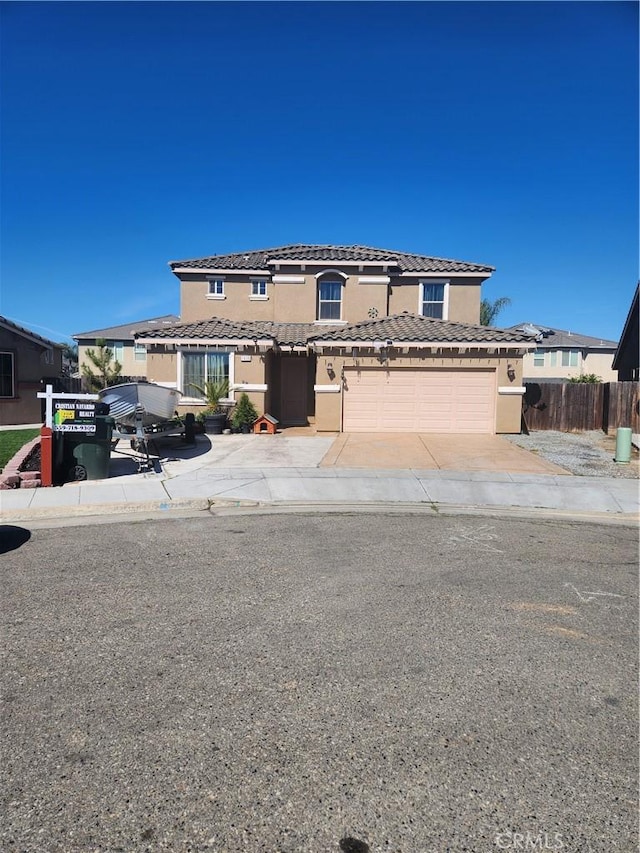 view of front of house featuring concrete driveway, fence, a tiled roof, and stucco siding