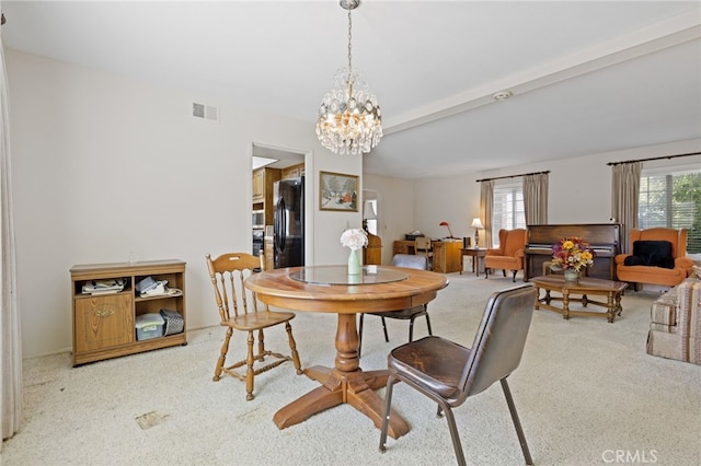 dining area with an inviting chandelier, carpet, visible vents, and a healthy amount of sunlight