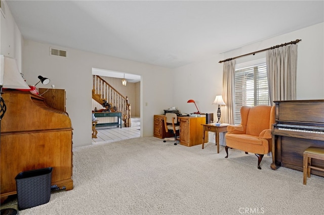 sitting room featuring carpet floors, stairway, and visible vents