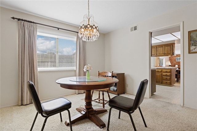 dining space with light carpet, a notable chandelier, visible vents, and baseboards