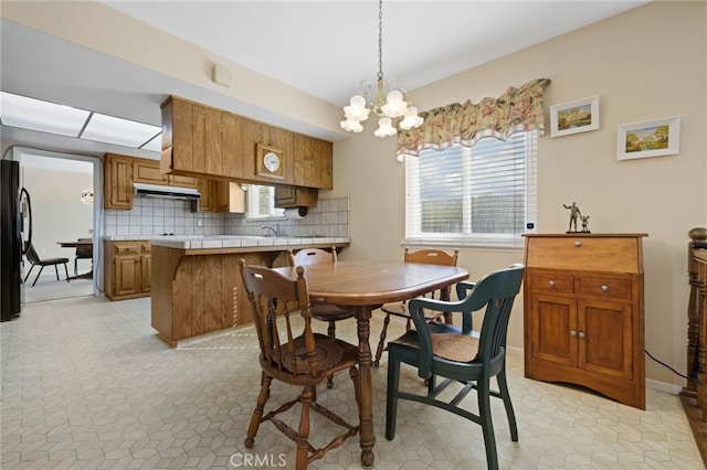 dining space featuring light floors, baseboards, and a notable chandelier