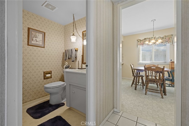 bathroom featuring wallpapered walls, visible vents, toilet, vanity, and a chandelier