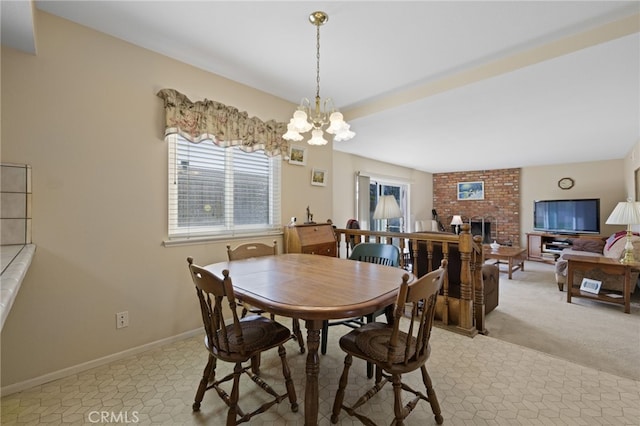 dining area featuring light carpet, an inviting chandelier, a fireplace, and baseboards