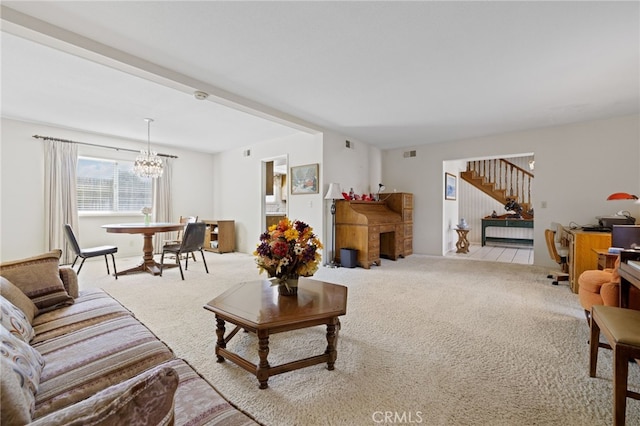 carpeted living area with an inviting chandelier, visible vents, and stairway