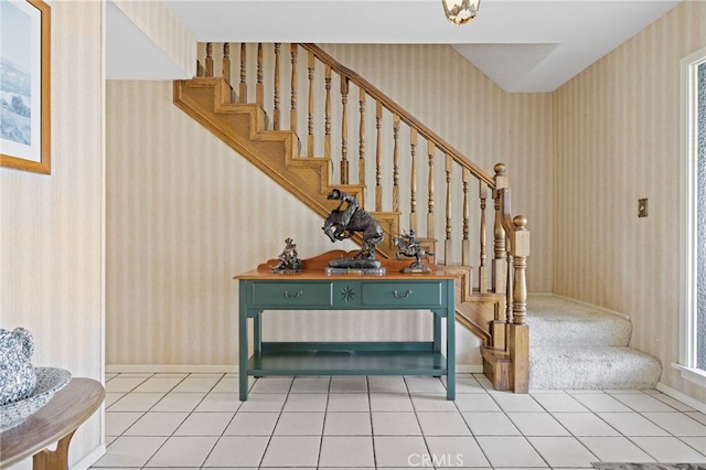 staircase with baseboards, tile patterned floors, and wallpapered walls