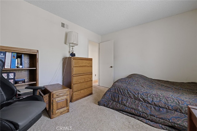 carpeted bedroom with a textured ceiling and visible vents