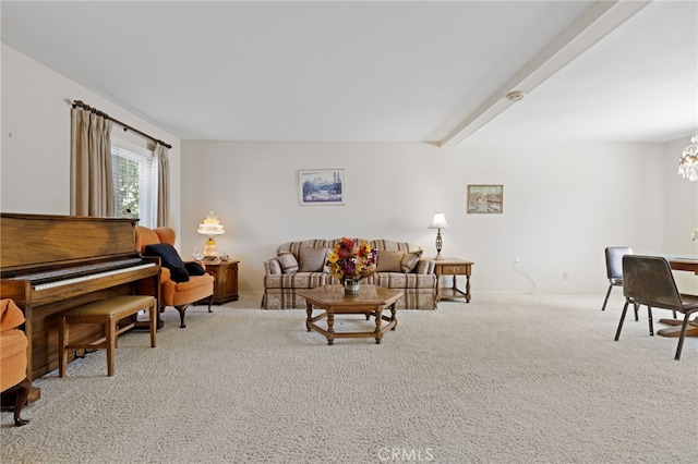 living area with carpet floors, an inviting chandelier, and beamed ceiling