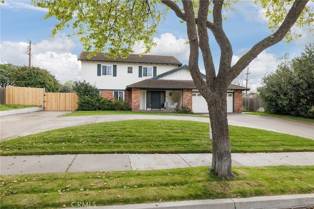 traditional home with driveway, brick siding, a front lawn, and fence