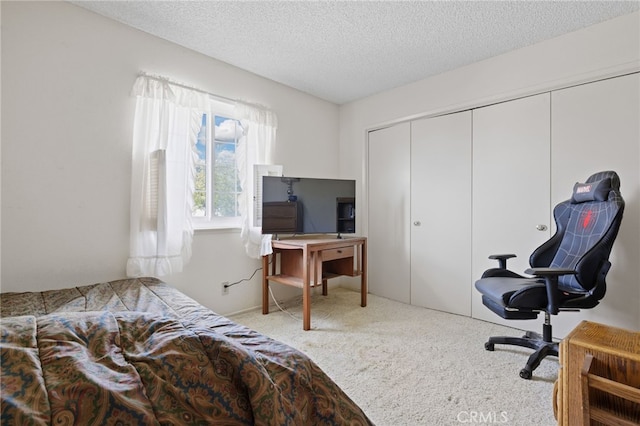 carpeted bedroom with a closet and a textured ceiling