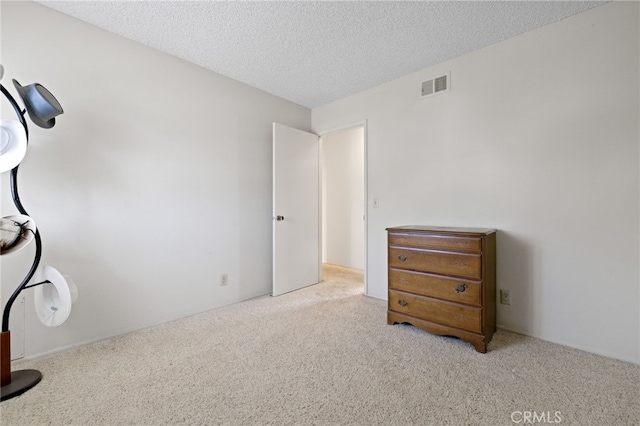 carpeted bedroom featuring visible vents and a textured ceiling