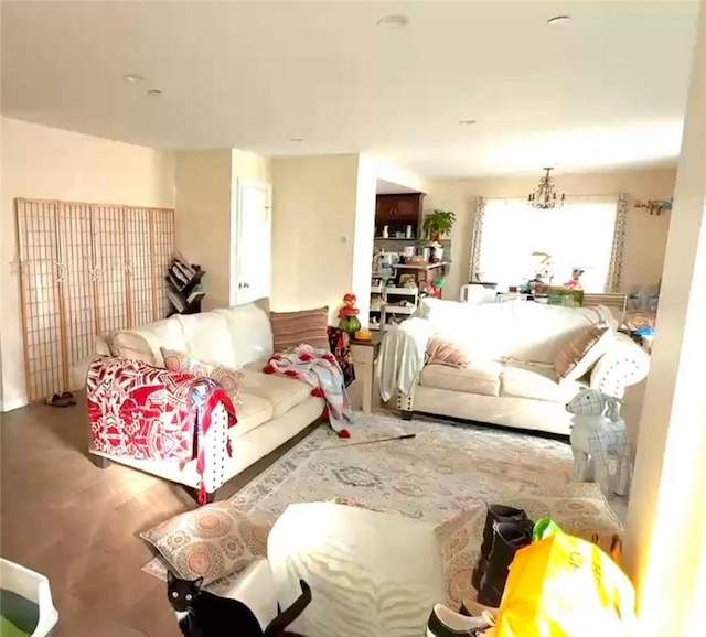 living area with wood finished floors and an inviting chandelier