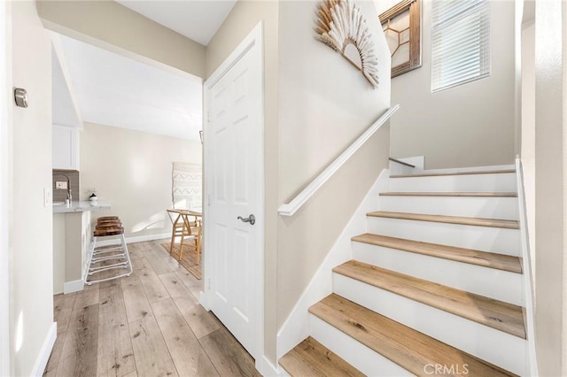 stairway with hardwood / wood-style flooring and baseboards