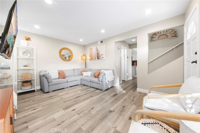 living room with light wood-style floors, recessed lighting, baseboards, and stairs