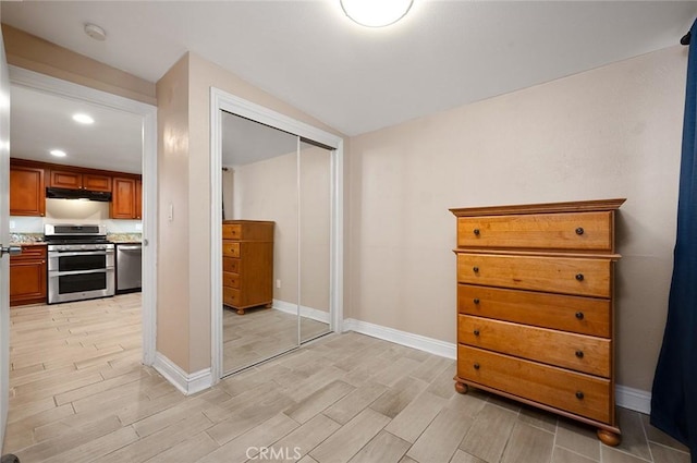 unfurnished bedroom with light wood-style floors, baseboards, and a closet