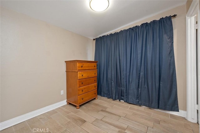 unfurnished room featuring baseboards and wood tiled floor