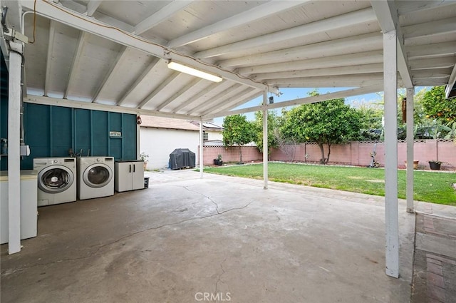 view of patio with a carport, separate washer and dryer, and fence