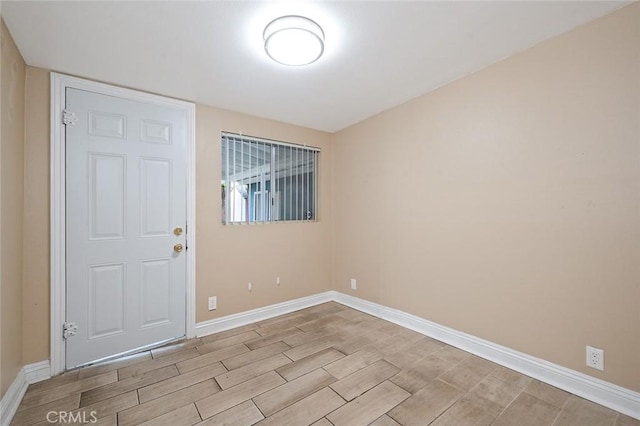 spare room with baseboards and wood tiled floor