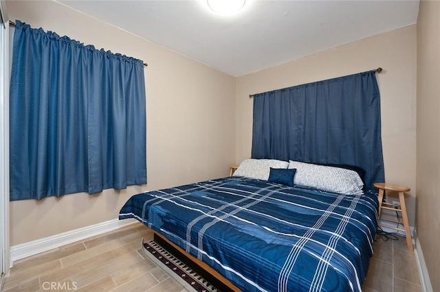 bedroom featuring baseboards and wood finished floors