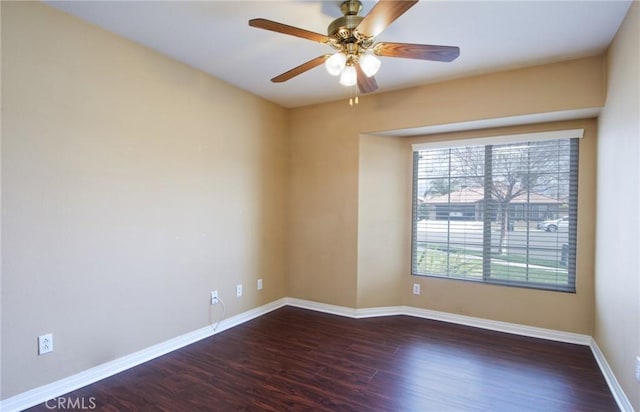 empty room featuring dark wood-style floors, ceiling fan, and baseboards