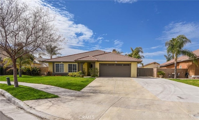 ranch-style home featuring a tiled roof, an attached garage, fence, a front lawn, and stucco siding