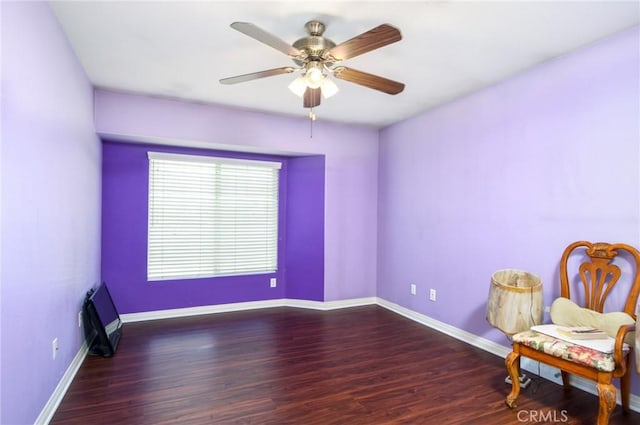 unfurnished room featuring wood finished floors, a ceiling fan, and baseboards