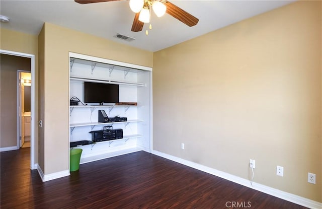 interior space with ceiling fan, wood finished floors, visible vents, and baseboards