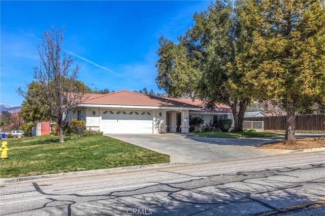 ranch-style home with an attached garage, fence, driveway, stucco siding, and a front lawn