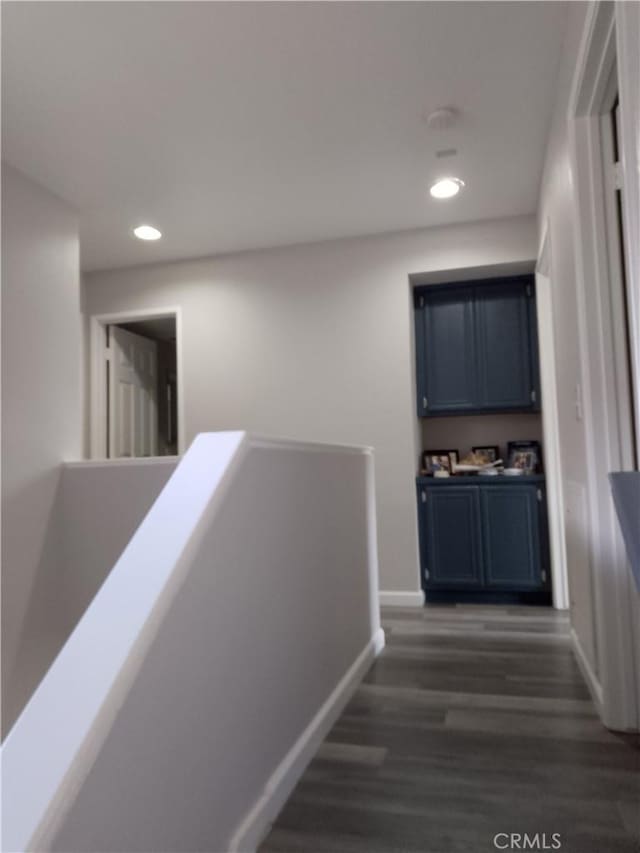 hall featuring recessed lighting, dark wood finished floors, an upstairs landing, and baseboards