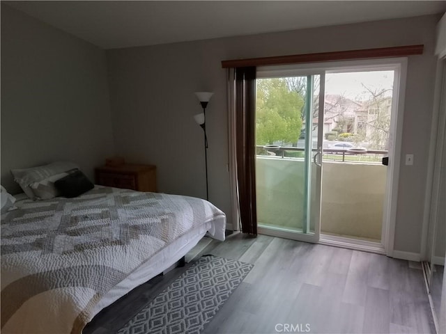 bedroom with light wood-type flooring, access to exterior, and baseboards